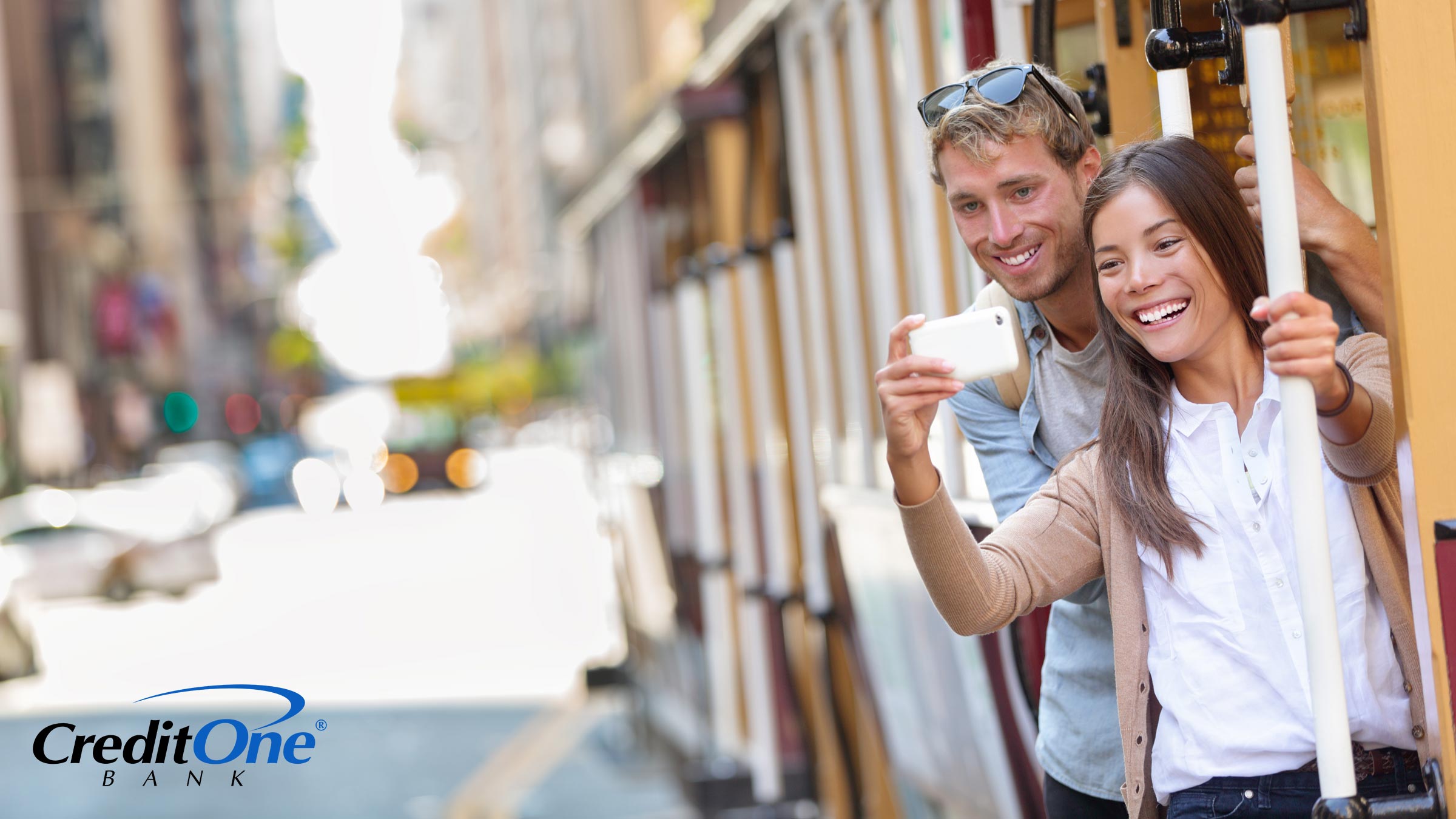 Tourists take a selfie while riding an iconic cable car on a budget travel vacation in San Francisco