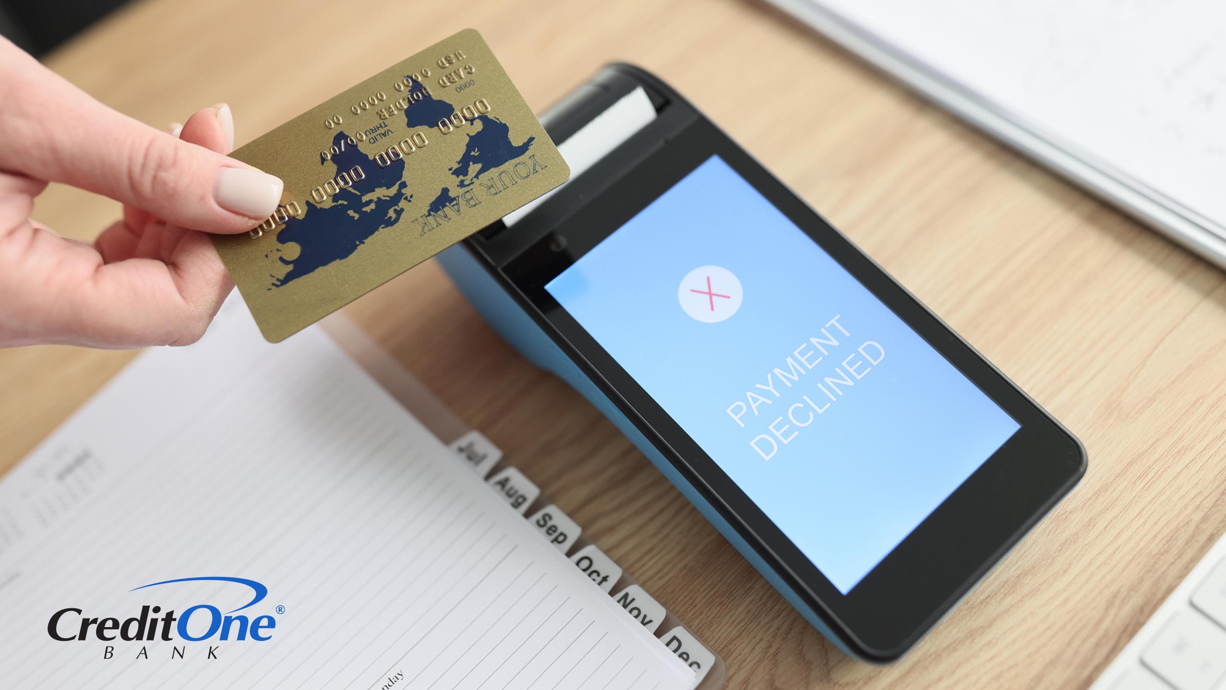 A woman’s hand is shown tapping her credit card at a terminal, which display a red X and the message “payment declined.” Perhaps this purchase would have caused her to go over her credit limit.